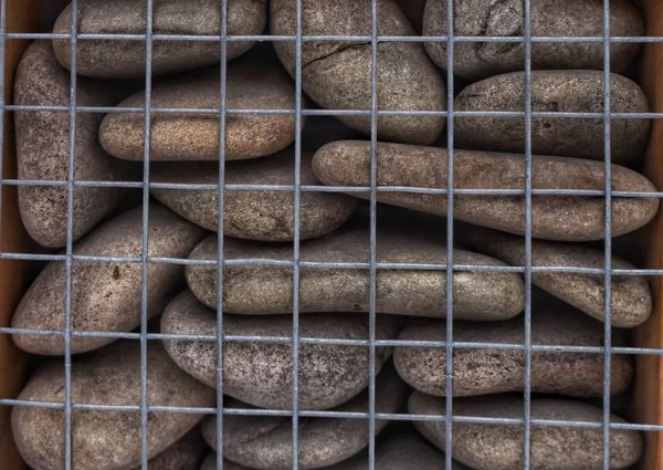Smooth stones piled behind bars
