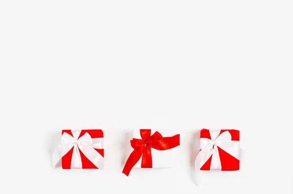 The concept of Valentines Day, March 8, holiday, celebration, anniversary. Gift boxes with red ribbons on a white background. — Stock Photo, Image