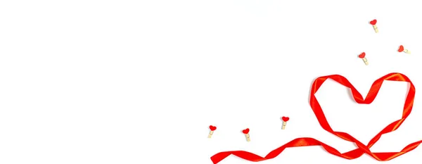 Η ιδέα του Αγίου Βαλεντίνου. Καρδιά από φωτεινή κόκκινη κορδέλα με διακοσμητικά μανταλάκια με καρδιά — Φωτογραφία Αρχείου