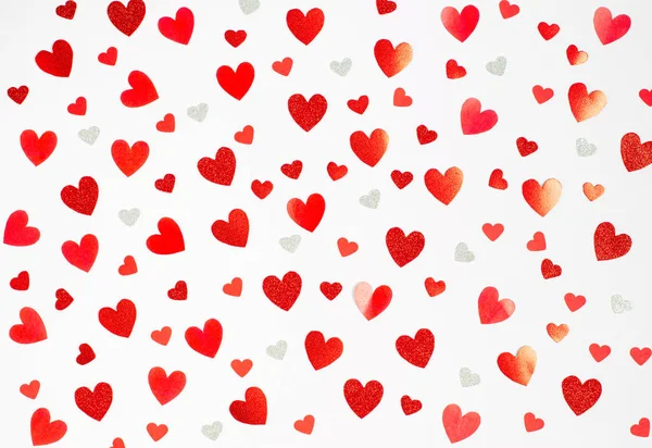 Valentijnsdag concept. Achtergrond van verschillende heldere rode harten op een witte achtergrond — Stockfoto