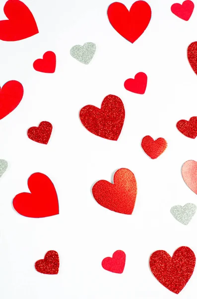 Valentijnsdag concept. Achtergrond van verschillende heldere rode harten op een witte achtergrond — Stockfoto