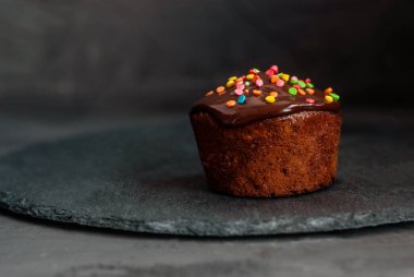 Çikolatalı ganache serpilmiş, renkli pasta süslemeleriyle süslenmiş balkabağı pastası.