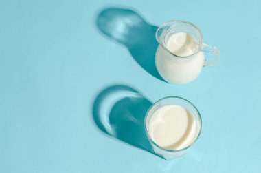 Ev yapımı mayalanmış içecek. Fotokopi alanı olan mavi bir arka planda kefir. Sert gölgeler. Ekşi süt içeceği, maya mayası mayası için ekşi ekmek, bağırsak sağlığı konsepti..