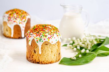 Beyaz arkaplanda beyaz şeker kreması ve renkli şekerleme tozuyla süslenmiş Paskalya pastası. Baharda geleneksel mevsimlik hamur işleri. Paskalya bayramı kutlaması. Yakın plan..