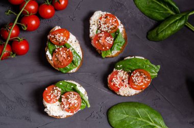 Krem peynirli ev yapımı sandviçler, domatesler, Yunan dürümündeki ıspanak koyu arkaplanda maya yok, fotokopi alanı. Düz yatıyordu. Sağlıklı beslenme, sağlıklı atıştırma. Yukarıdan görüntüle.