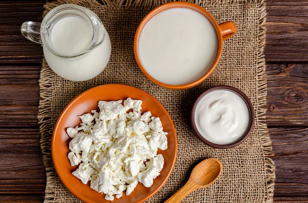 Ev yapımı mayalanmış süt ürünleri - kefir, ahşap arka planda süzme peynir. Sağlıklı beslenme konsepti. Maya mayası fermantasyonu, bağırsak sağlığı konsepti. Yukarıdan görüntüle.