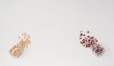 Cam kavanozlarda vejetaryenler için çeşitli kuru tahıllar: nohut, beyaz arka planda fasulye. Protein ve karbonhidrat açısından sağlıklı gıdaları kopyalayın. Yukarıdan görüntüle.