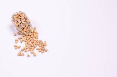 Beyaz arka planda cam bir kavanozda vejetaryenler için kuru nohut, fotokopi alanı, mesaj için yer. Yüksek miktarda protein ve karbonhidrat içeren sağlıklı yiyecekler. Yakın plan..