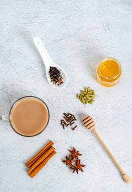 Geleneksel kızılderili yemeği pişirmek için malzemelerle birlikte cam bir fincanda masala çayı içer. Tarçın, kakule, anason, bal, karanfil, arka planda kuru çay. Yukarıdan bak. Düz taban. Dikey yönelim