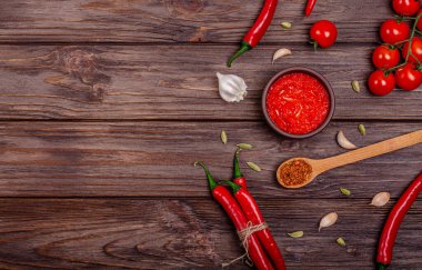 Ayvar ya da pindjur kırmızı sebze ezmesi ya da kil kasede biber biberi ve domates kreması ve kırsal ahşap bir masa üzerindeki malzemeler. Sırp yerlisi, geleneksel yemekler. Uzayı kopyala Yukarıdan görüntüle.