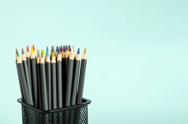 Mavi arka plandaki bir çantada renkli kalemler. Çizim, yaratıcılık, hobiler, dersler, kırtasiye malzemeleri. Düz konum, kopyalama alanı, Tex için alan. Yakın plan..