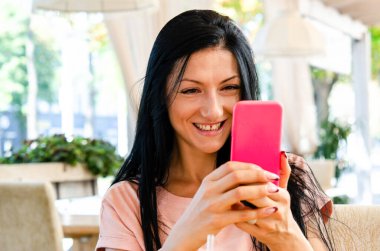 Genç tatlı bir kız evdeki, sokaktaki akıllı bir telefondan selfie çekiyor, cep telefonuyla uzaktan iletişim kuruyor, aile videosunu telefonda kaydediyor..