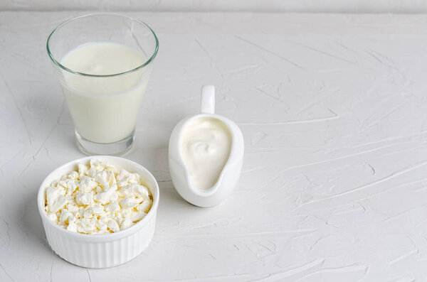 Домашний бродильный напиток в бокале кефира, творог, сметана на белом фоне, копировальное место. Кислый молочный напиток, закваска для бактериального брожения дрожжей, концепция здоровья кишечника
.