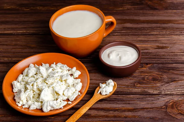 Ev yapımı süt ürünleri - kefir, süzme peynir, ahşap arka planda ekşi krema, fotokopi alanı, düz yatak. Maya mayası fermantasyonu, bağırsak sağlığı konsepti. Yukarıdan görüntüle.