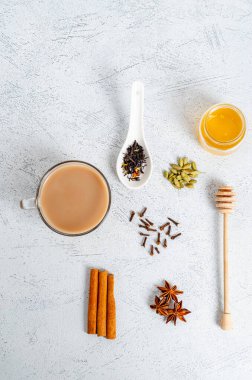 Geleneksel kızılderili yemeği pişirmek için malzemelerle birlikte cam bir fincanda masala çayı içer. Tarçın, kakule, anason, bal, karanfil, arka planda kuru çay. Yukarıdan bak. Düz taban. Dikey yönelim