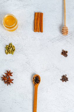 Geleneksel Hint içkisi çayı hazırlamak için çerçeve şeklinde malzemeler. Tarçın, kakule, anason, bal, karanfil, arka planda kuru çay. Yukarıdan bak. Boşluğu kopyala,