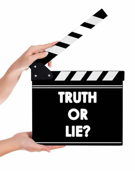 Händer som håller en filmklappa med sanning eller lögn text — Stockfoto