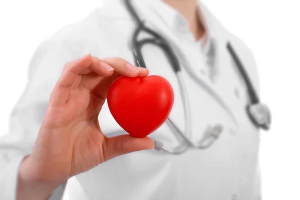 Положительная женщина-врач, стоящая со стетоскопом и красным сердцем — стоковое фото
