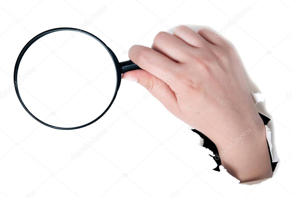 Female hand holding the magnifying glass isolated on white backg