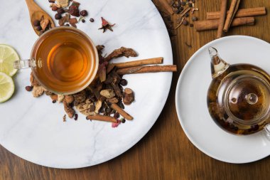 Farklı siyah ve yeşil kuru çay ile Gıda arka plan, koyu ahşap arka plan üzerinde sıcak çay ve demir çaydanlık gül tomurcukları fincan. Çay içme konsepti. Üst te. Kare görüntü