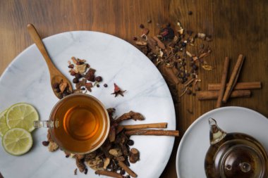 Farklı siyah ve yeşil kuru çay ile Gıda arka plan, koyu ahşap arka plan üzerinde sıcak çay ve demir çaydanlık gül tomurcukları fincan. Çay içme konsepti. Üst te. Kare görüntü