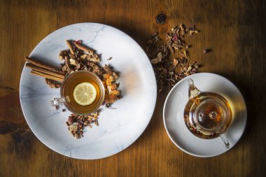 Farklı siyah ve yeşil kuru çay ile Gıda arka plan, koyu ahşap arka plan üzerinde sıcak çay ve demir çaydanlık gül tomurcukları fincan. Çay içme konsepti. Üst te. Kare görüntü