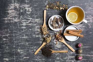 Farklı siyah ve yeşil kuru çay ile Gıda arka plan, koyu ahşap arka plan üzerinde sıcak çay ve demir çaydanlık gül tomurcukları fincan. Çay içme konsepti. Üst te. Kare görüntü
