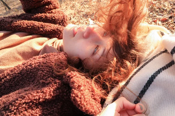 Fille aux cheveux roux se reposant et profitant du soleil couchant — Photo