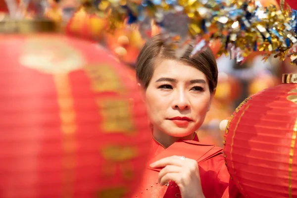 An Asian woman is carrying a red envelope on Chinese New Year.