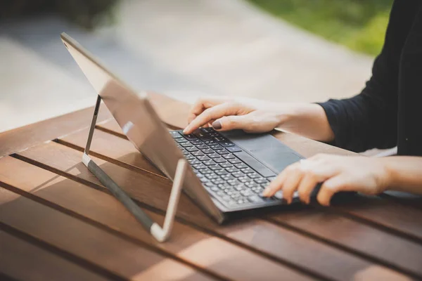 Dizüstü bilgisayarla yazıp çalışan bir kadının elleri..