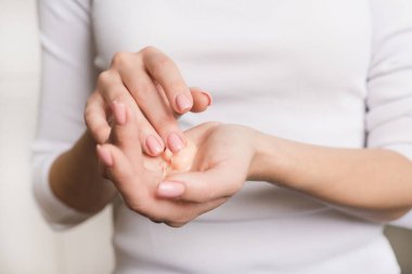 Beyaz uzun kollu güzel kız ellerini kremle nemlendiriyor. Çiviler yumuşak ipek gibi sağlıklı bir cilde kozmetik el kremi sürüyor. Güzellik ve Vücut Bakımı