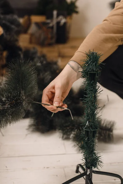 Чоловік збирає вдома штучне різдвяне дерево. Етап Асамблеї деревовидного дерева. Настанова і допомога — стокове фото