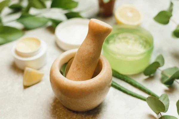 mixing ingredients to create cosmetics in a marble mortar. Herbal cosmetic ingredients. A mixture of aloe leaves, eucalyptus branches, lemon to create a gel, skin cream