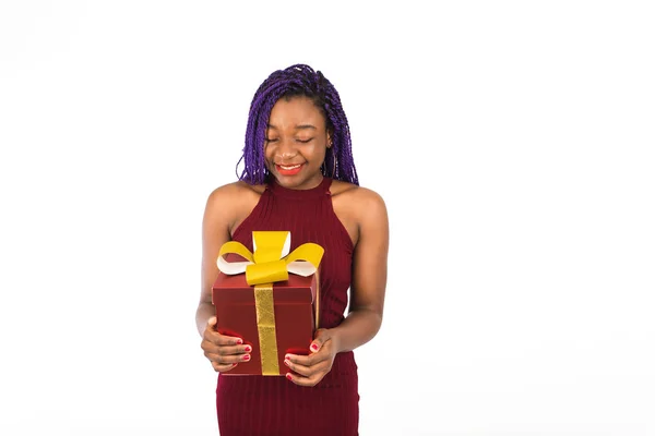 Uma menina negra desfruta de um grande presente vermelho de Natal. Menina sorri e recebe presente. Isolado sobre fundo branco — Fotografia de Stock