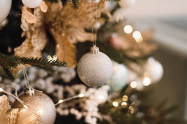 Yılbaşı ağacındaki gümüş Noel balosu yanan ışık çelenklerinin arka planında. Parlak arkaplanda Noel ağacı süsleme.