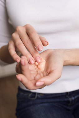 Beyaz uzun kollu güzel kız ellerini kremle nemlendiriyor. Çiviler yumuşak ipek gibi sağlıklı bir cilde kozmetik el kremi sürüyor. Güzellik ve Vücut Bakımı