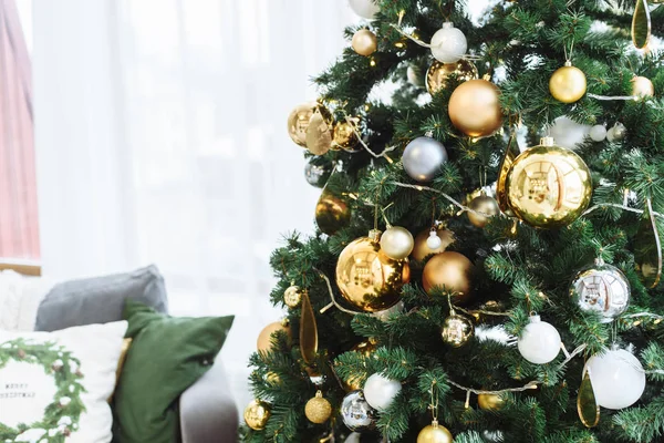 Nieuwjaarsdennenboom met decoraties en verlichting. Kerstboom decoraties achtergrond. Veel grote gouden ballen op dennenboom Nieuwjaar en Kerstmis. Kerstboom met gouden en bruine ballen op een groene — Stockfoto