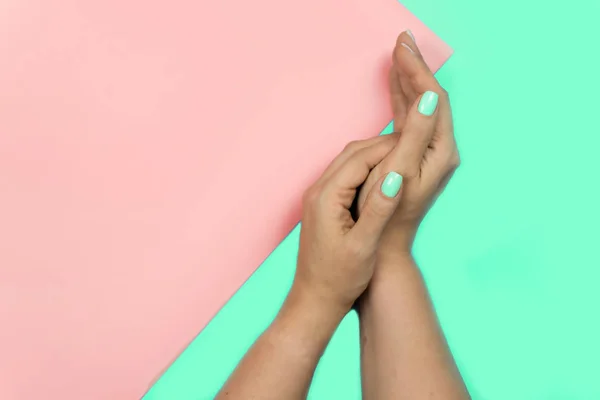 Elegante moda femenina azul nueva manicura. Hermosas manos de mujeres jóvenes sobre fondo rosa y azul. aqua menthe, El color del año 2020 — Foto de Stock
