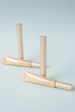 Pastel mavi arka planda farklı bir altın rimel, desen. Dekoratif rimel koleksiyonu