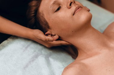 Kız masöz bir erkeğe yüz masajı yapar. Masör genç bir adamın boynuna masaj yapıyor. Boyun ve omurga ağrısının tedavisi tıbbi masajla yapılır.