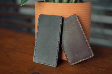 bir tencerede bir çiçek arka planda iki eko-deri telefon kapakları. Erkek ve kadın deri aksesuarlar. Hayvanları koruma konsepti