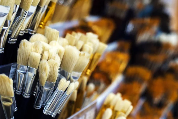 Group of artistic paintbrushes for artist. New paint brushes on shelf display in stationery shop. Art painting concept. The concept of selling tools for artists, the choice of brushes