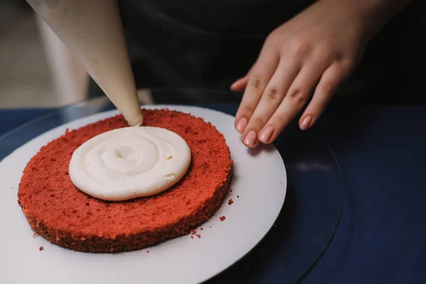 Pudra kek üzerine krema sıkar. Kız bir kek yapmak — Stok fotoğraf