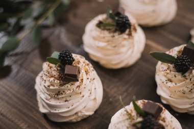 Krem rengi Pavlova kremalı, çikolatalı, ahşap bir o 'nun üzerinde.