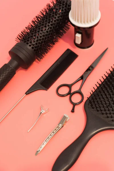 Composición plana con peluquería sobre fondo rosa. Juego de peluquería con herramientas y equipo: tijeras, peines y pinzas para el cabello. Peluquería y servicio de salón de belleza —  Fotos de Stock