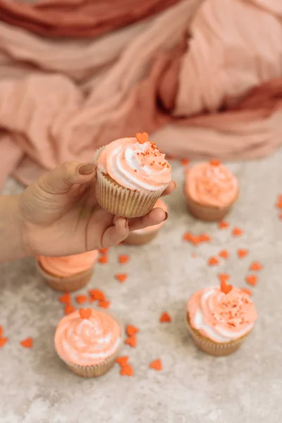 Chica sosteniendo una magdalena con crema rosa en el día de San Valentín. El hombre da dulzura al día de San Valentín — Foto de Stock