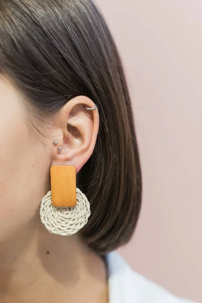 Стильные круглые геометрические жемчужные серьги на ухе девушки с стрижкой Боба. Пастельно-розовый фон — стоковое фото