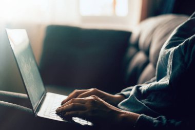 Ev işlerinde çalışan bir kadın klavyeyi kapatıyor. Güzel bir kadın evdeki kanepede dizüstü bilgisayarla oturuyor ve evden çalışıyor. Serbest konsept