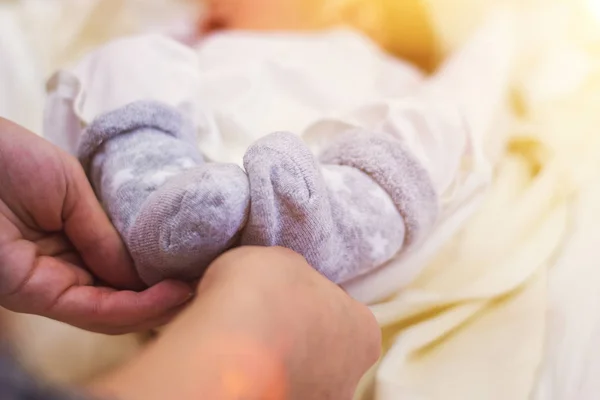 Füße eines neugeborenen Babys in den Händen der Eltern. das Konzept von Liebe, gesunder Geburt und glücklichen jungen Eltern — Stockfoto