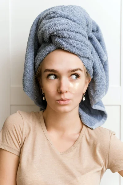 Patch for the area under the eyes. Facial skin care. A young girl watches her skin. Surprised and funny face of a girl during a morning routine — Stockfoto